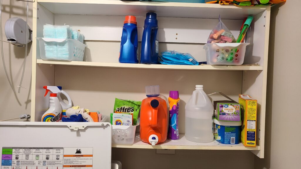 A closeup the open laundry cabinet space. Items are organized in their bins.