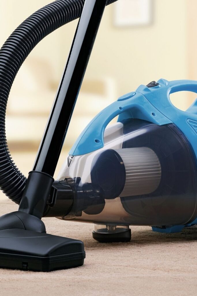 A blue vacuum with a long handle.