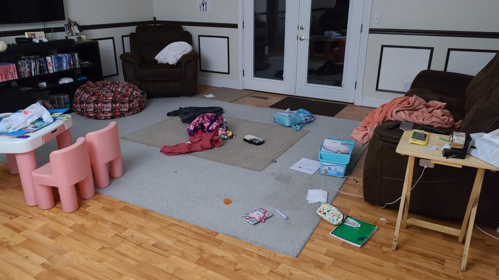 A living room with a cluttered floor