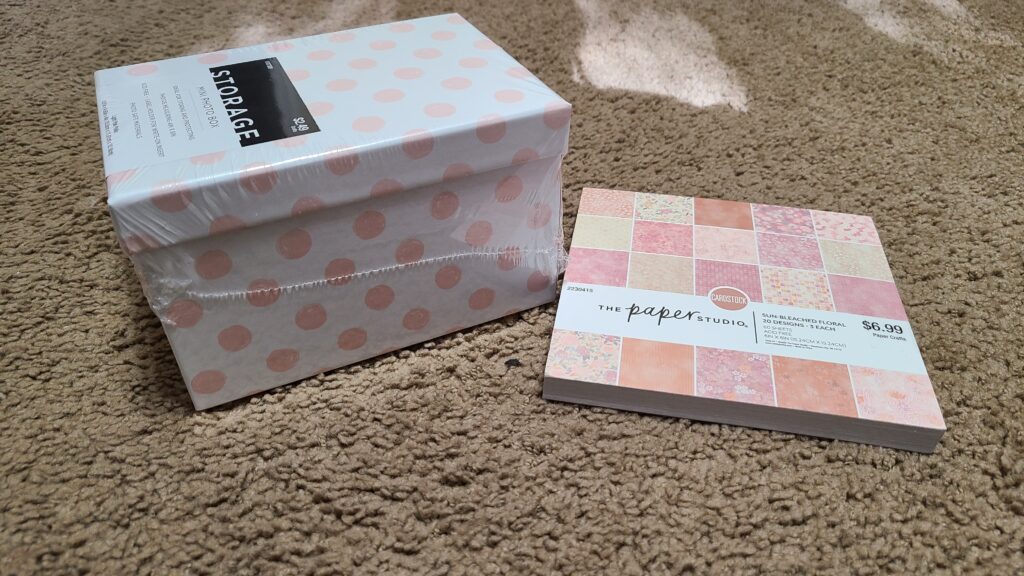 A small photo box, sitting next to a book of cardstock