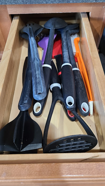 A skinny kitchen drawer filled with utensils