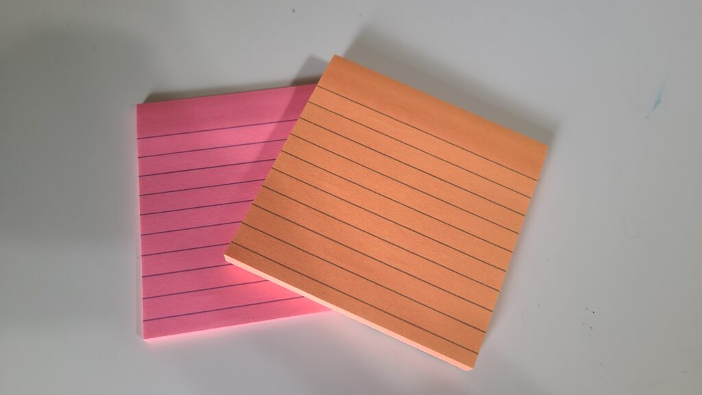 Two stacks of Post-it notes on a desk top
