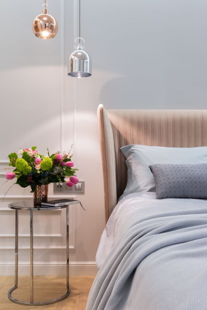 A closeup of a bed and a night stand in a bedroom.