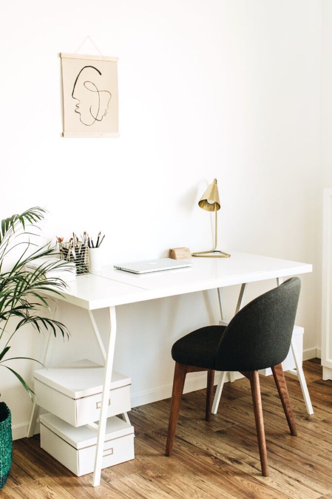 A plain small desk with a chair pushed underneath