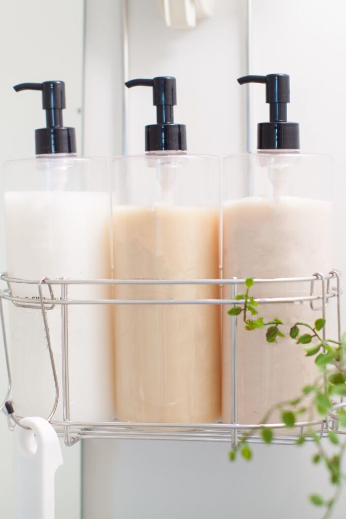 A close-up of 3 shampoo bottles inside a shower caddy