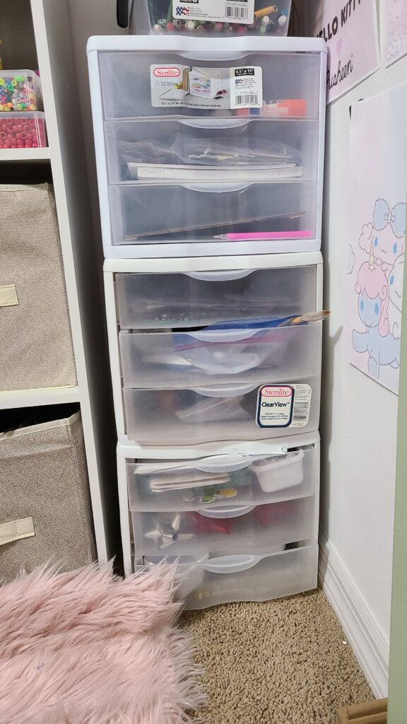 Three Sterilite stackable drawers in an open closet, filled with art supplies