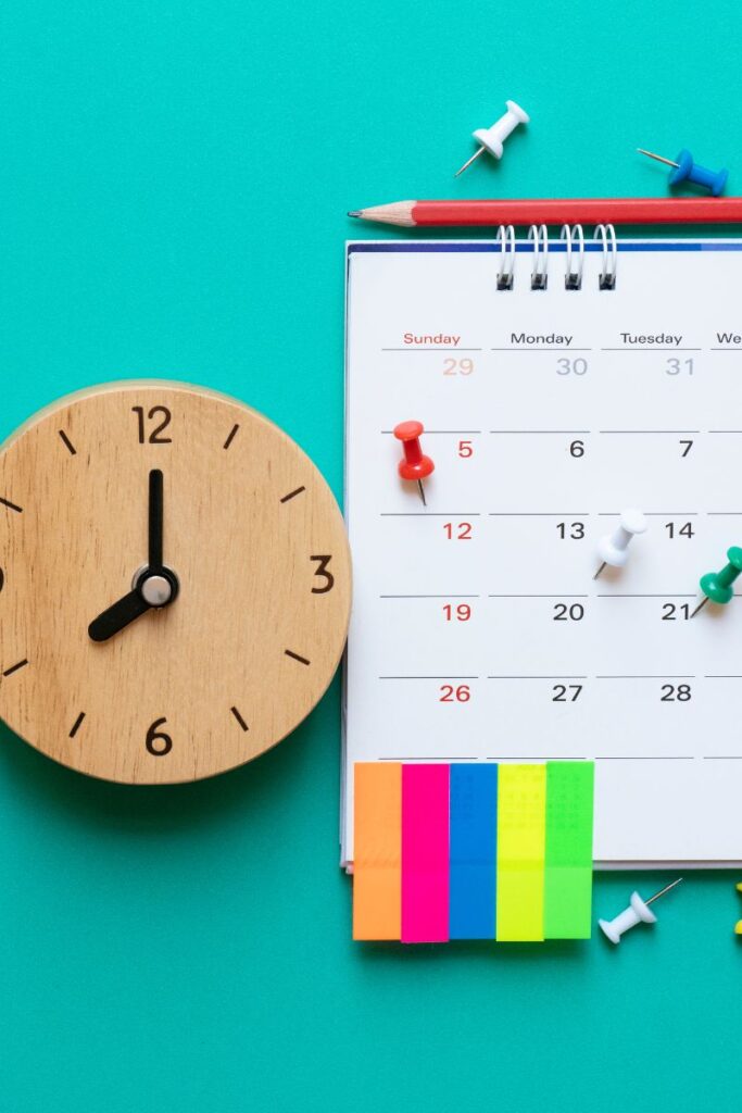 A wall calendar next to a wooden clock