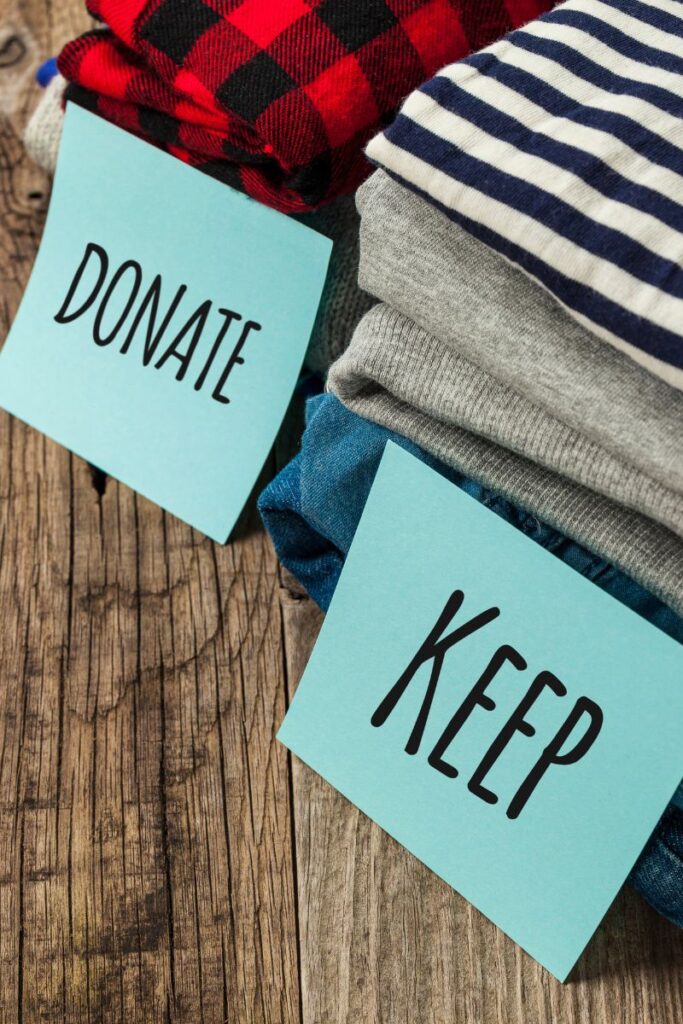 Two piles of clothes. There are signs in front of each one, saying "Donate" and "Keep".
