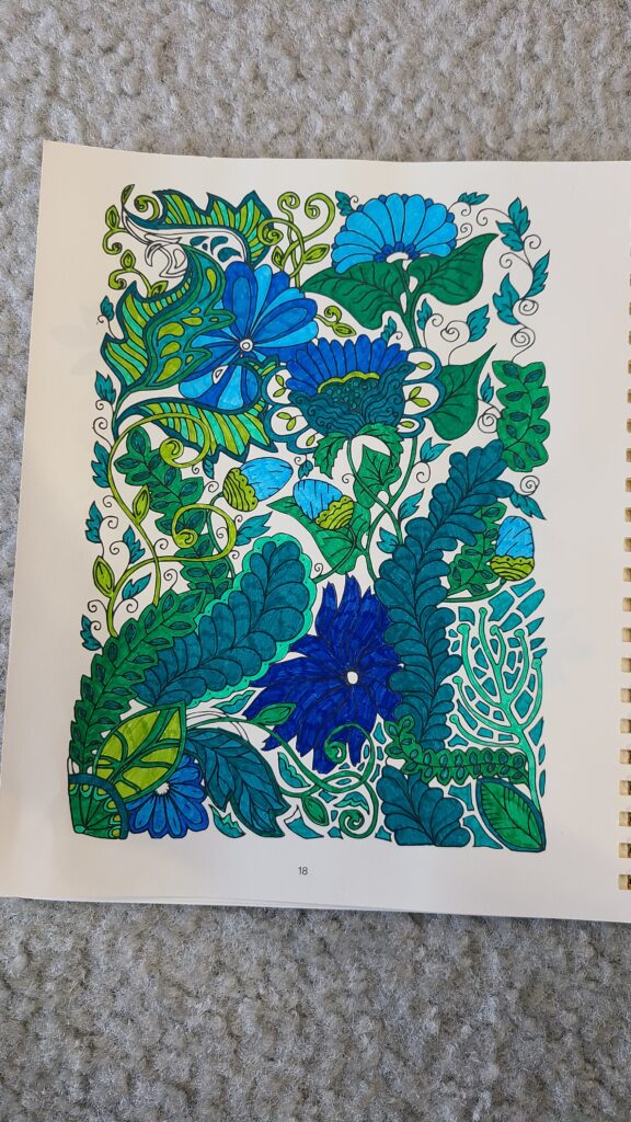 An opened Silk and Sonder planner, to the coloring page that has been colored in.