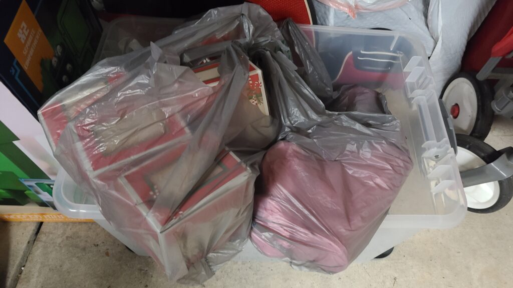A large clear storage bin filled with donation items