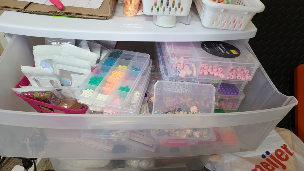 A large drawer filled with beads and crafting supplies